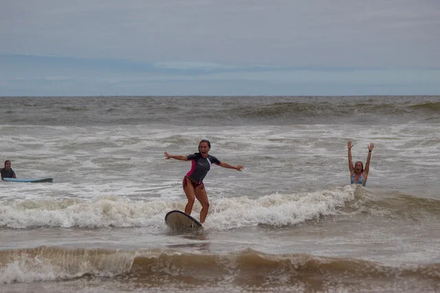 (Left: Karen Slattery, happily atop her first wave. Right: Proud teacher Rachel Sandquist pumping her fists)