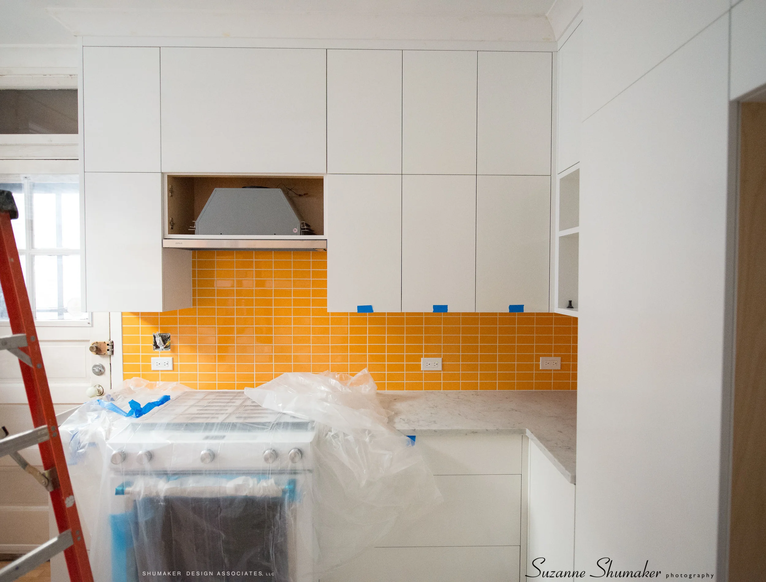 At today's site visit we selected a wall paint color to go with these custom cabinets and orange (sunset) back splash !!