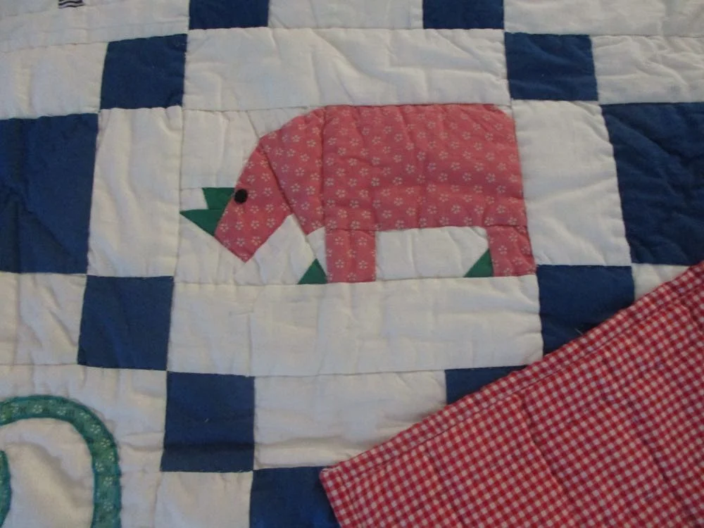 This applique hippo has green details that help it stand out in the overall design.