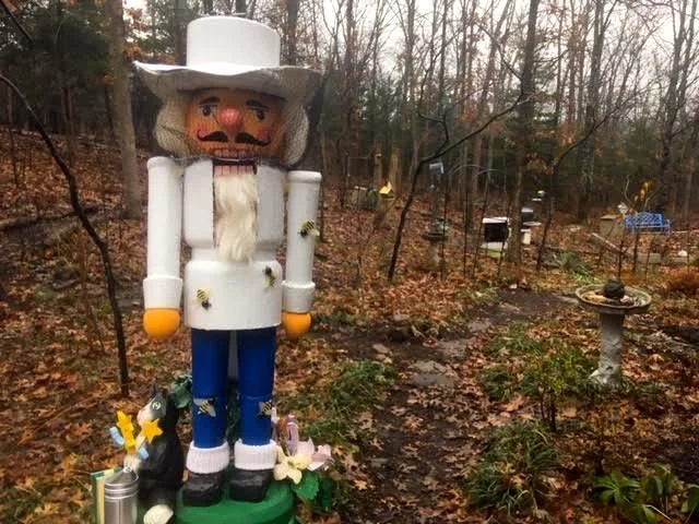 The finished beekeeper nutcracker with bee hives in the background. (Photo by Charlotte Ekker Wiggins)