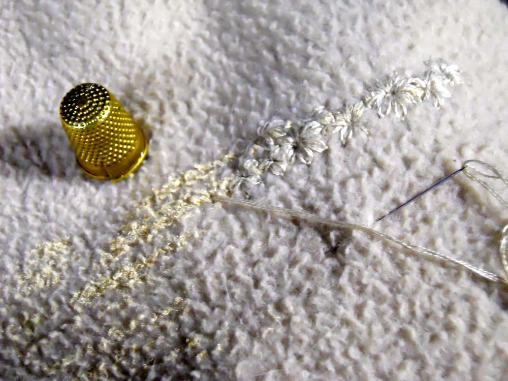 Simple daisy flower embroidery can cover paint stains on fleece. (Photo by Charlotte Ekker Wiggins)
