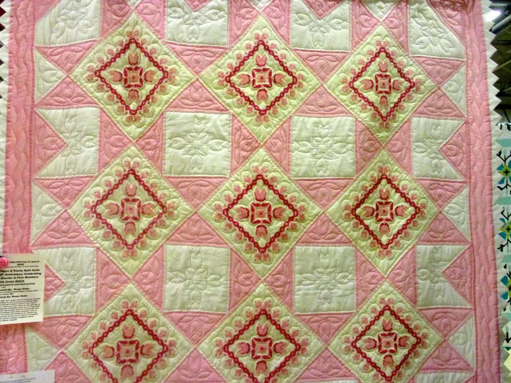 Pink Cross Stitch handmade quilt repeats the pattern in the quilting. (Photo by Charlotte Ekker Wiggins)