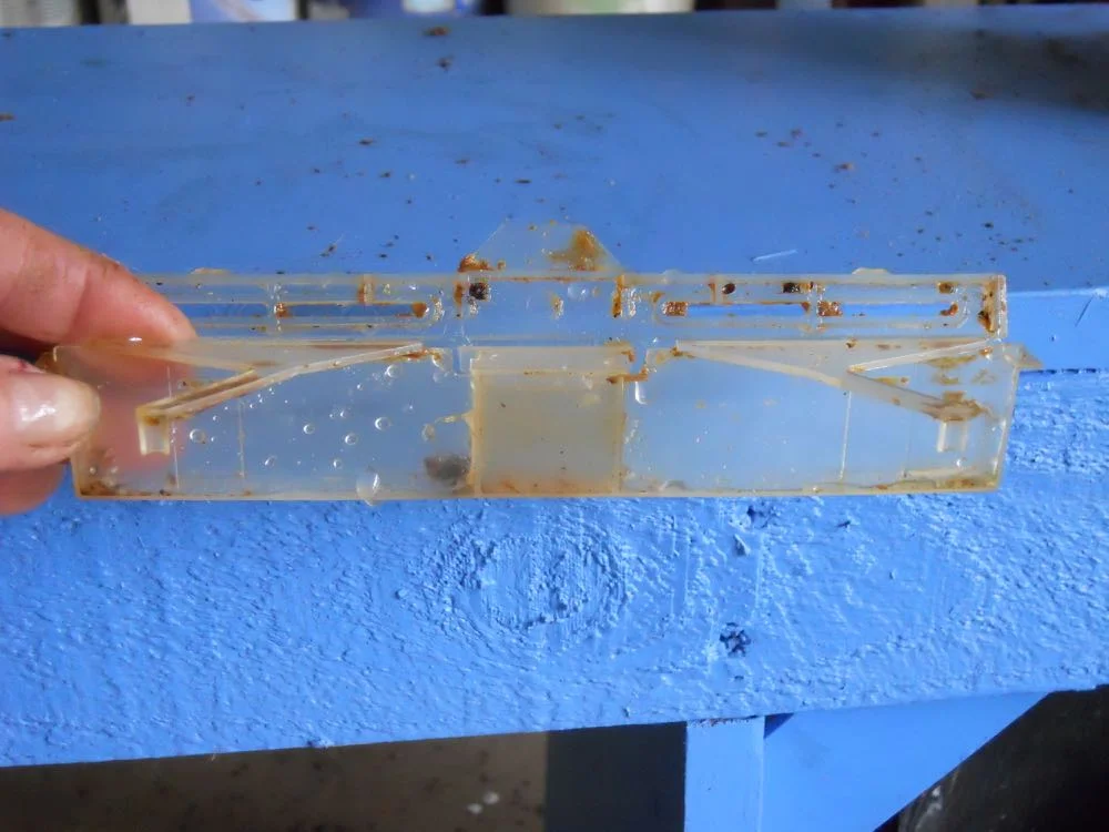 A reusable small hive beetle trap filled with a homemade small hive beetle lure in center well.