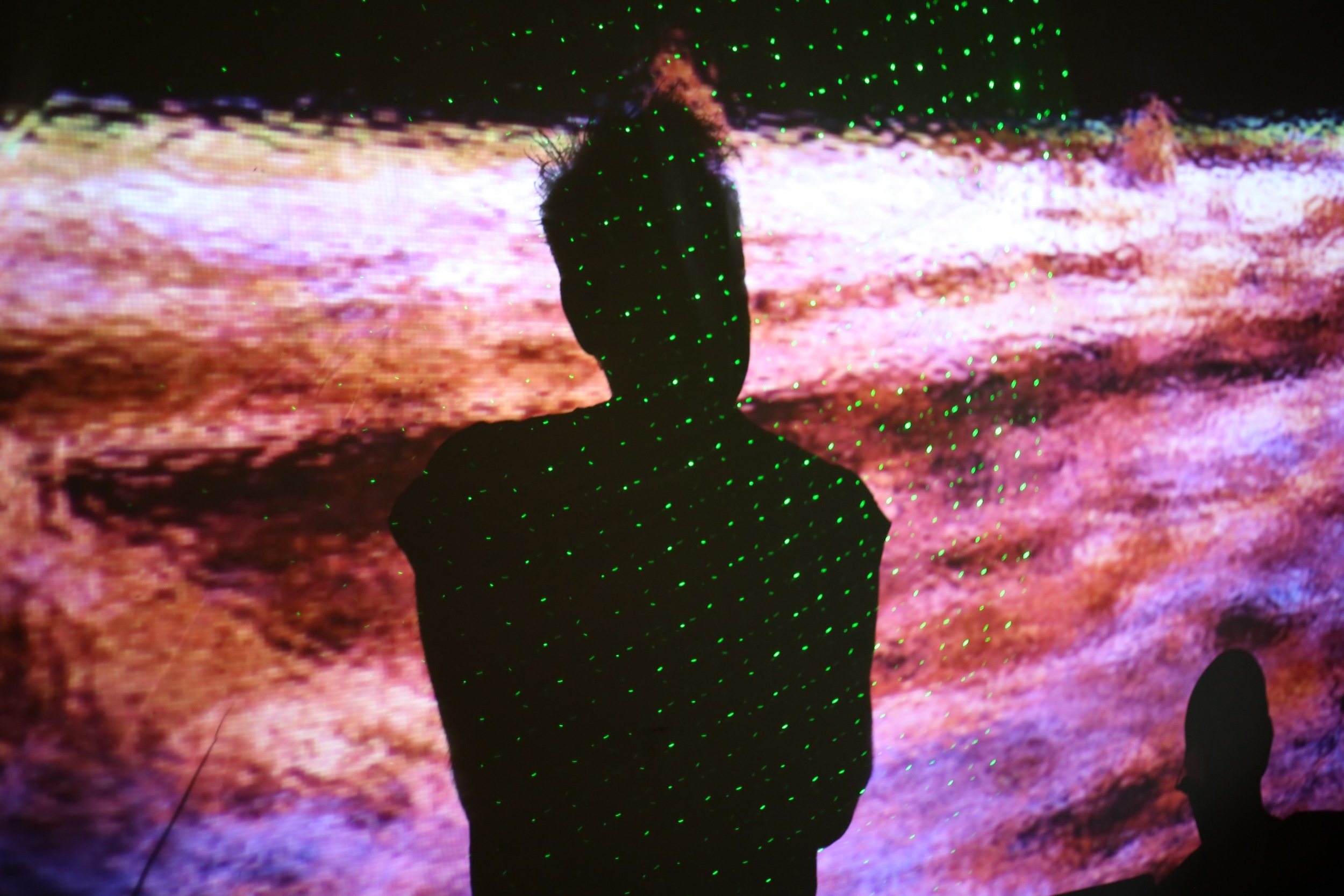 Paul Godwin in silhouette, projected image by Ameera.