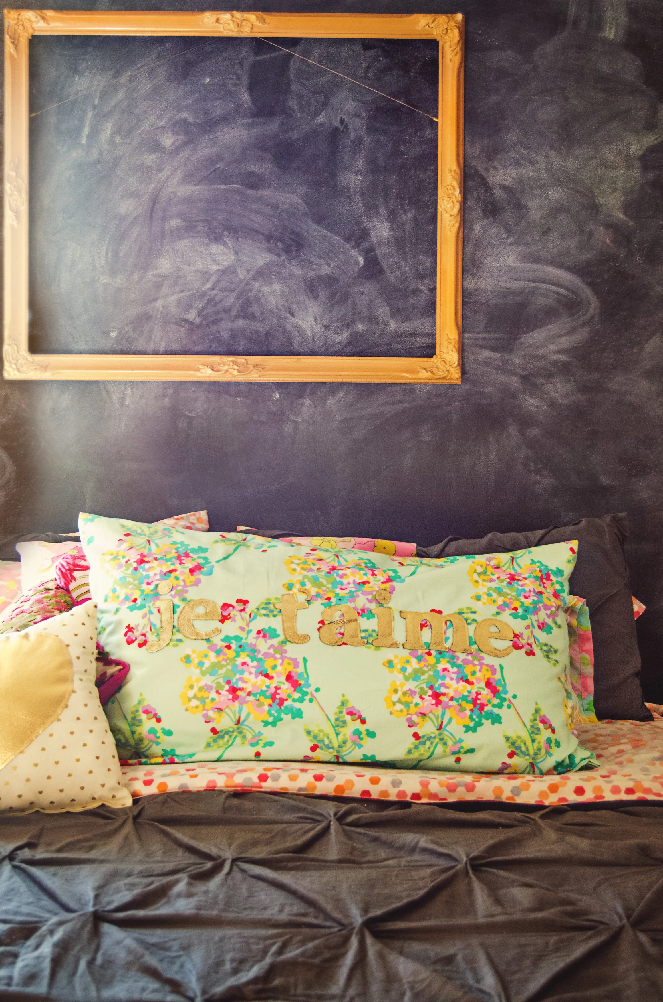 Chalkboard wall behind the bed with a gold frame. | hprallandco.com