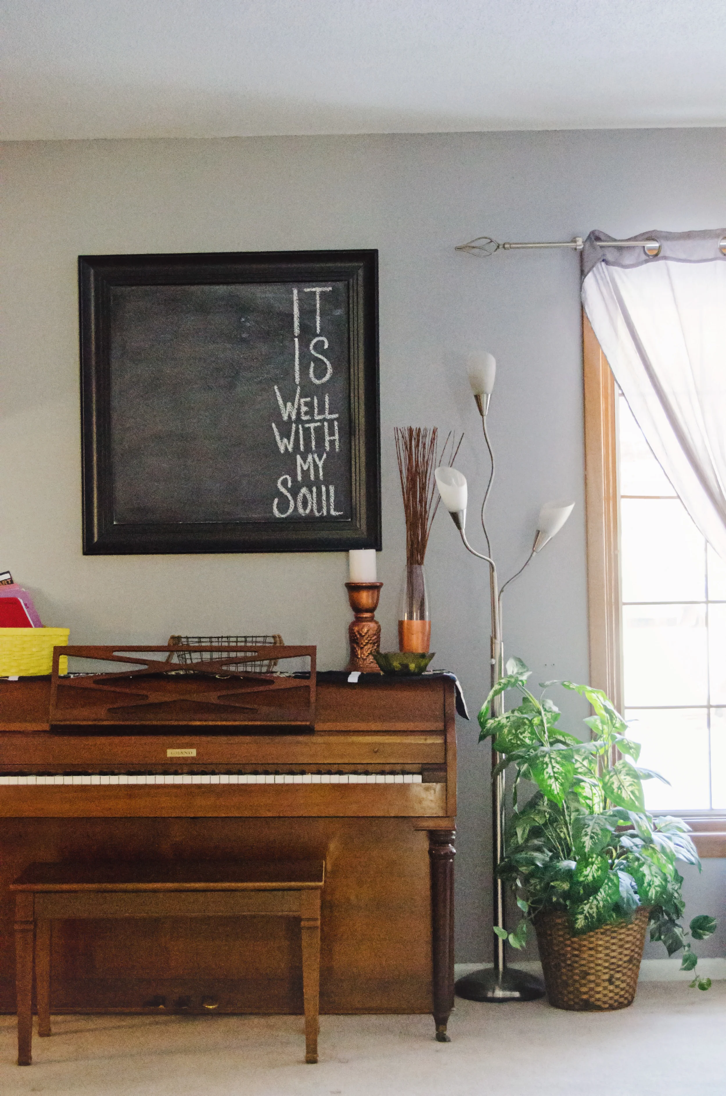 Framed chalkboard as wall decor hanging over a piano. | hprallandco.com