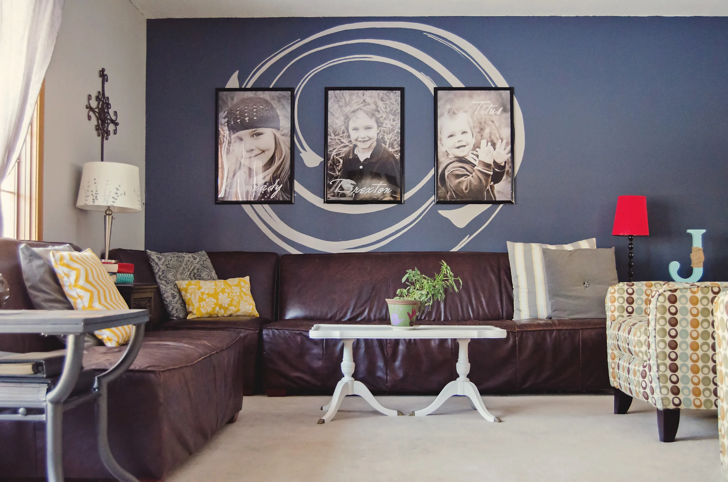 Living room with a blue accent wall and oversized family photos. | hprallandco.com