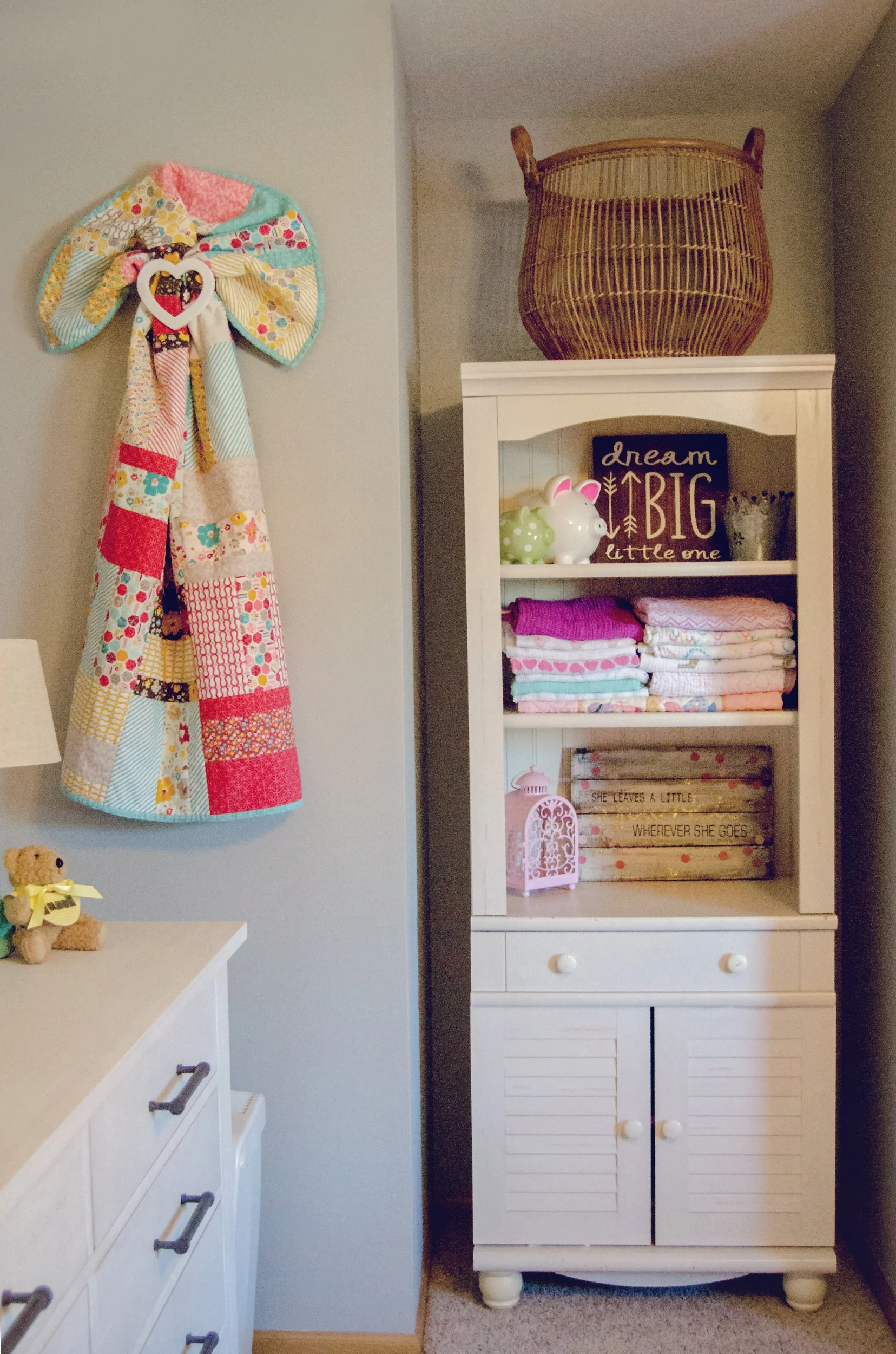 White hutch as nursery storage with a colorful quilt wall hanging. | hprallandco.com