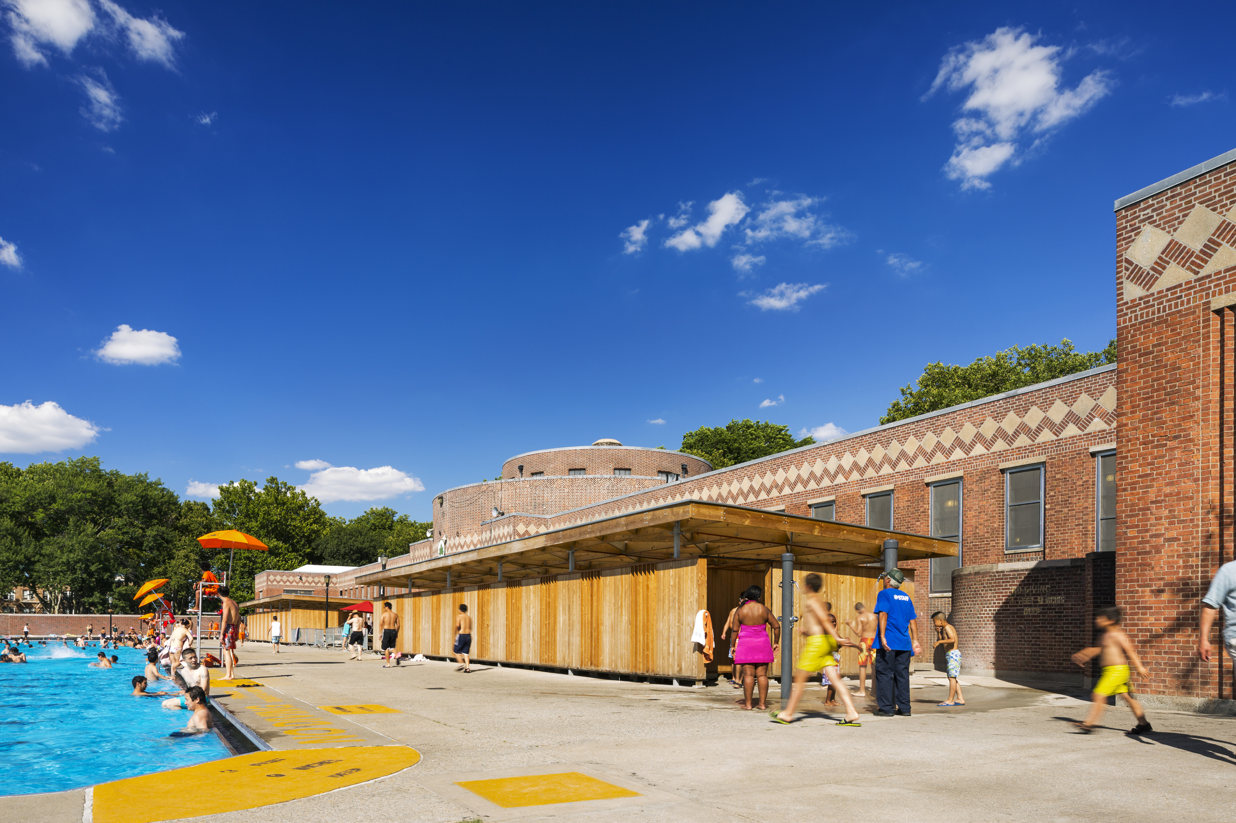 The new pavilions ensure that the interior programs can operate year round providing more services to the community. Additionally, pool patrons have new, private space to change and store their belongings, improving their overall experience at the pool. The pavilions complement the Landmark features, adding a new dimension to a historic site. ( ESTO / Albert Vecerka ) 