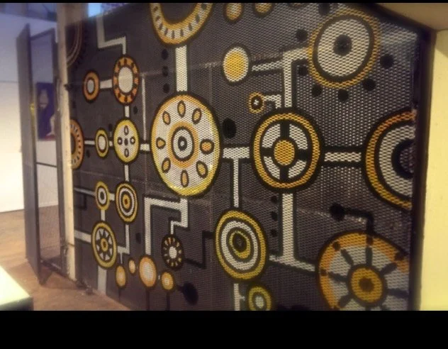Decorative wall with yellow, black, and white circular geometric patterns connected by lines and dots.