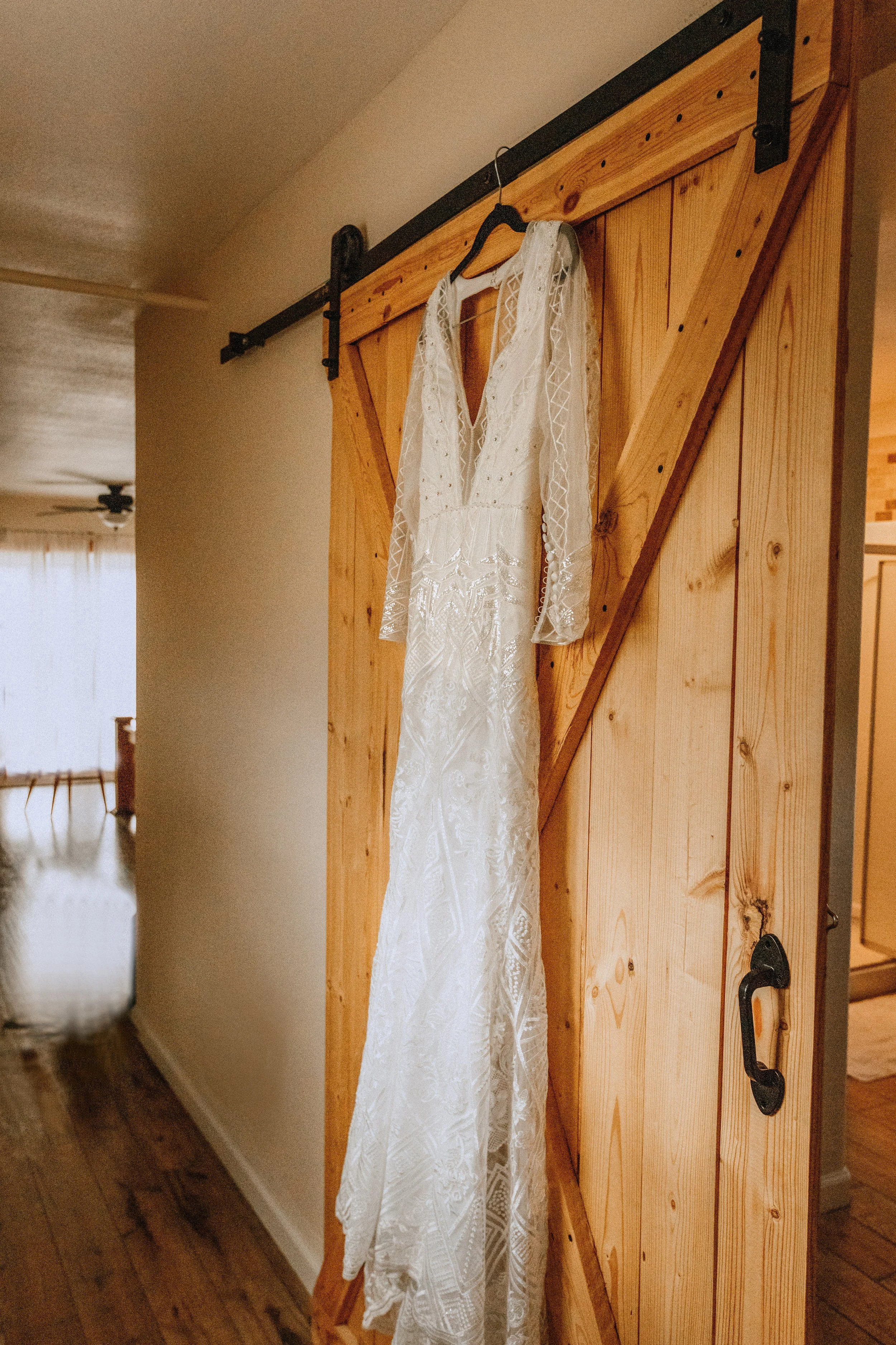 Wedding Dress Hangs from Barn Door in Loft at Rugged Horizon