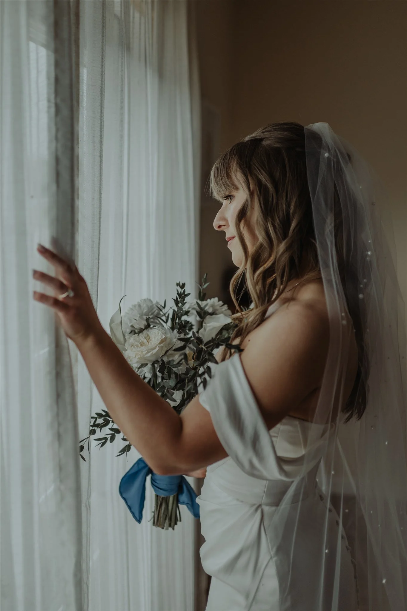 Bride Looks Out Balcony Window at Rugged Horizon Wedding Venue