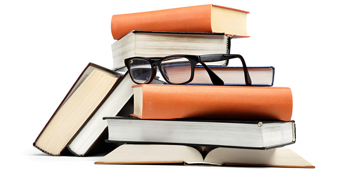 UNA IMAGEN DE UNOS LIBROS EN UNA BIBLIOTECA CON UNAS GAFAS JUSTO ENCIMA DE ESTOS LIBROS. FLICKR