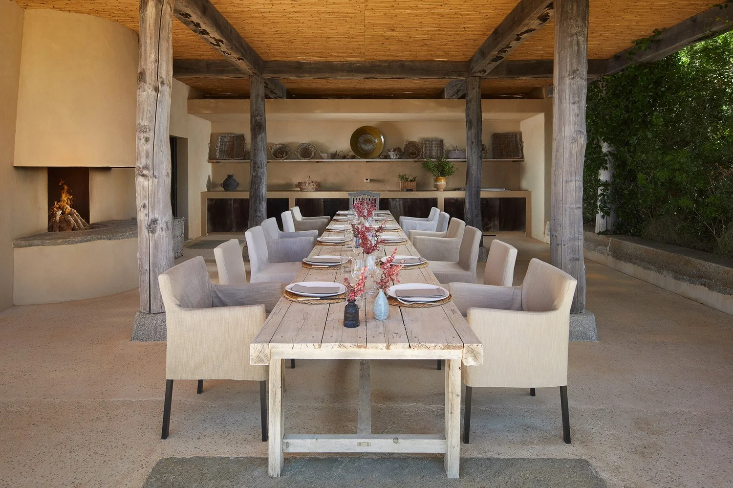Comedor exterior con mesa preparada bajo una cubierta de madera