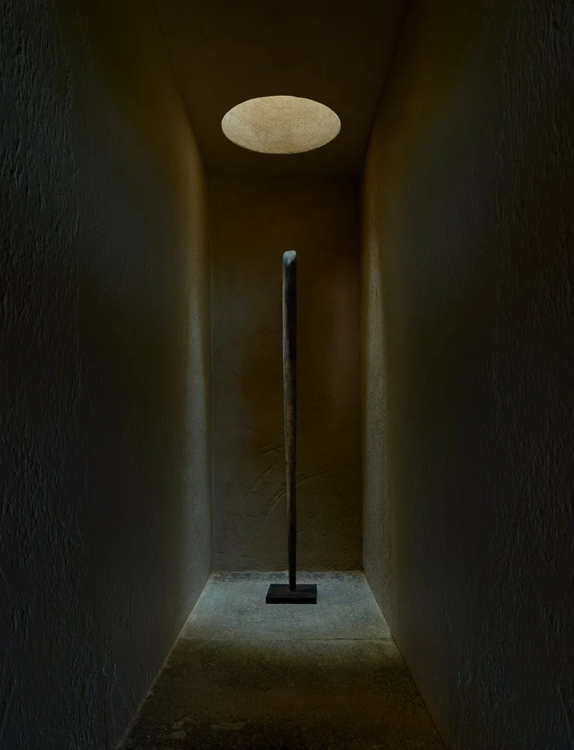Pieza escultórica vertical iluminada por un lucernario circular