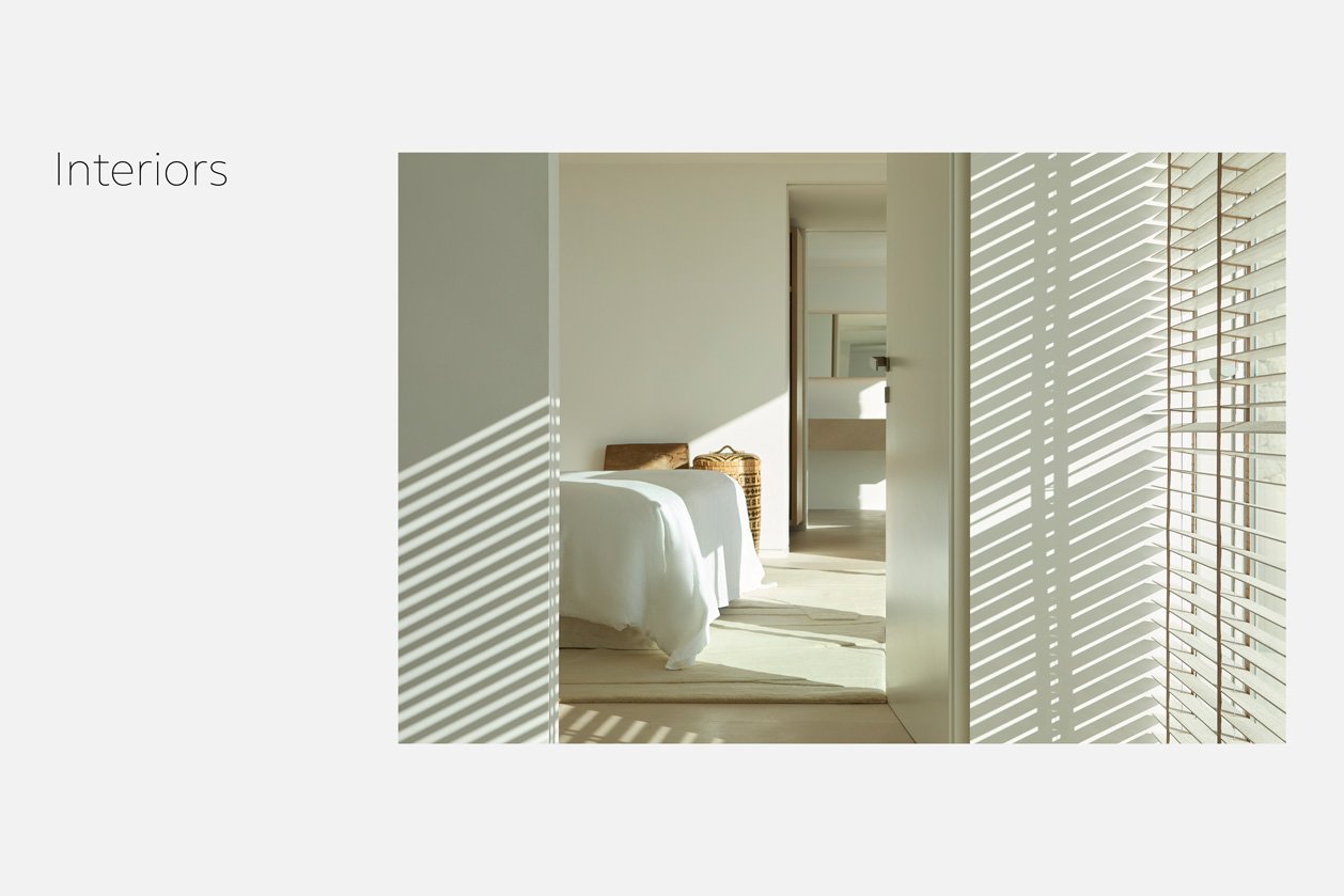 Dormitorio blanco con luz y sombras de las persianas sobre las paredes