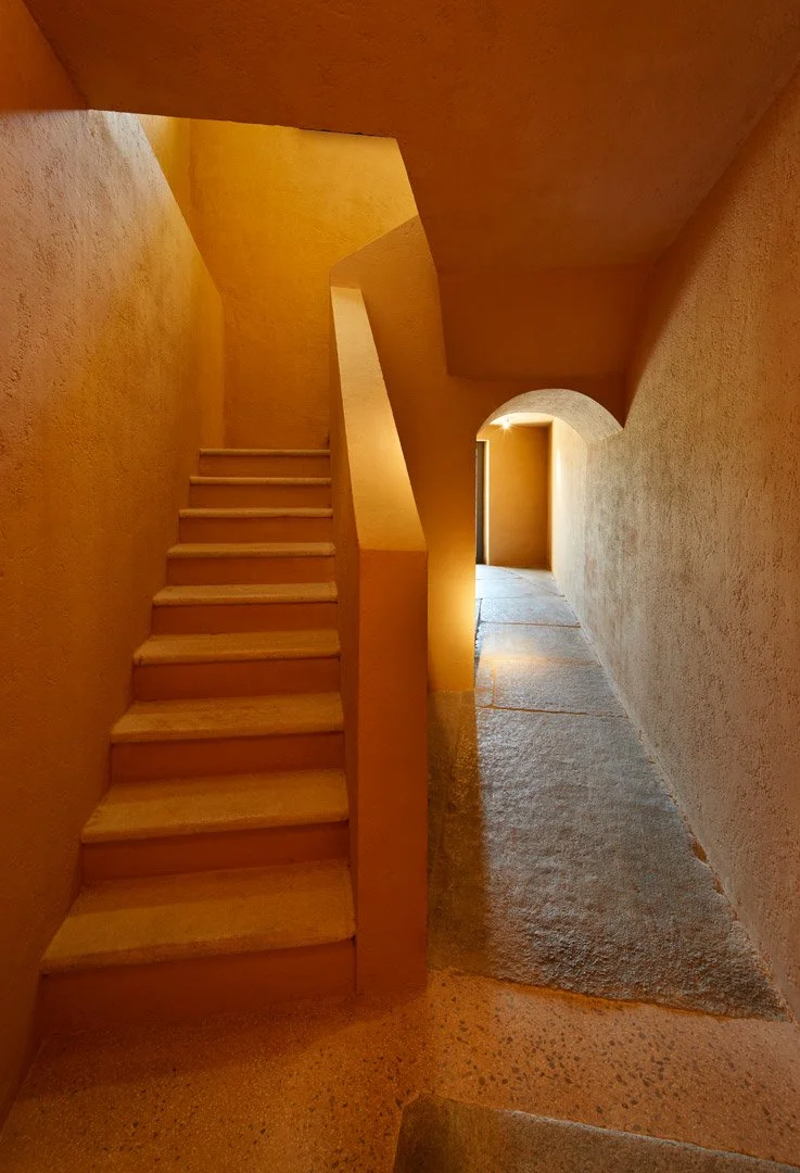 Encuentro entre una escalera y un pasillo estrecho de paredes texturadas