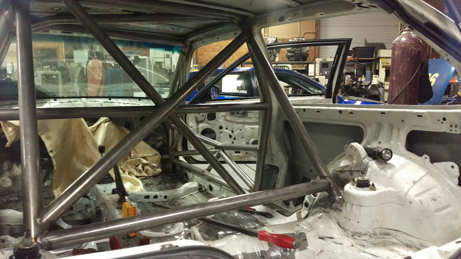 the rear shock towers are a good place to plant the rear downbars on these cars. strong, multi layered sheetmetal, and lots ofstructural gusseting lies in the shock tower area on most cars. and, the downtubes can be shorter. shorter is better. It is common for people to connect the lower areas of the shock tower intersection and the door bars as well, creating another load path and reinforcing the door bar. . 