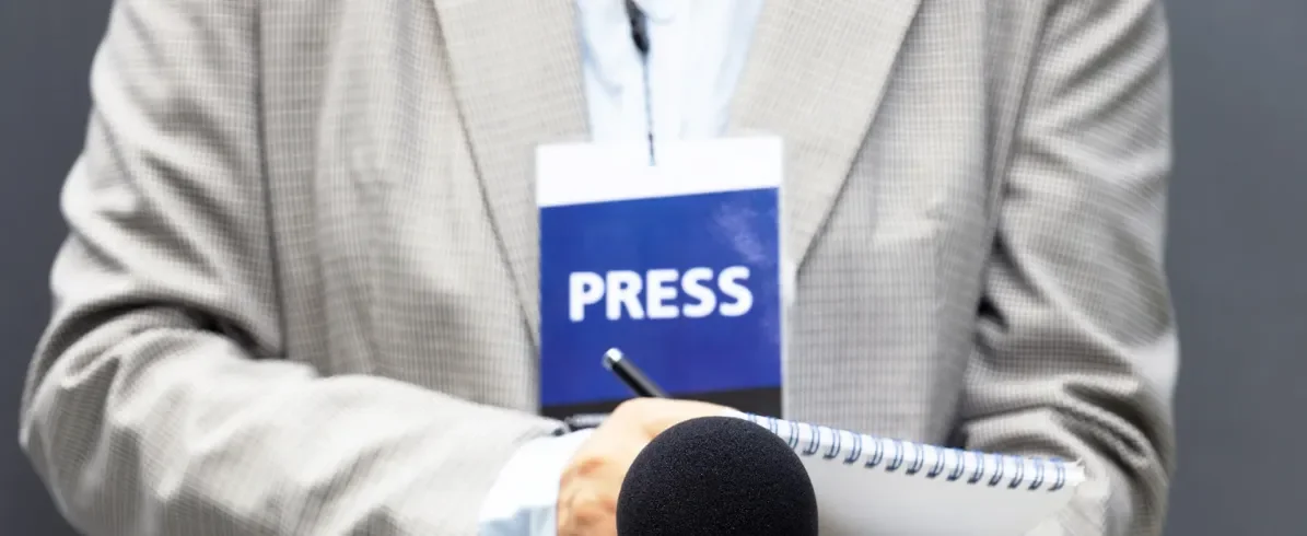 reporter with a microphone and a tablet and pen