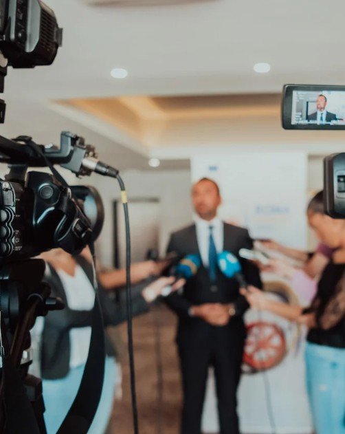 An executive being interviewed by multiple journalists