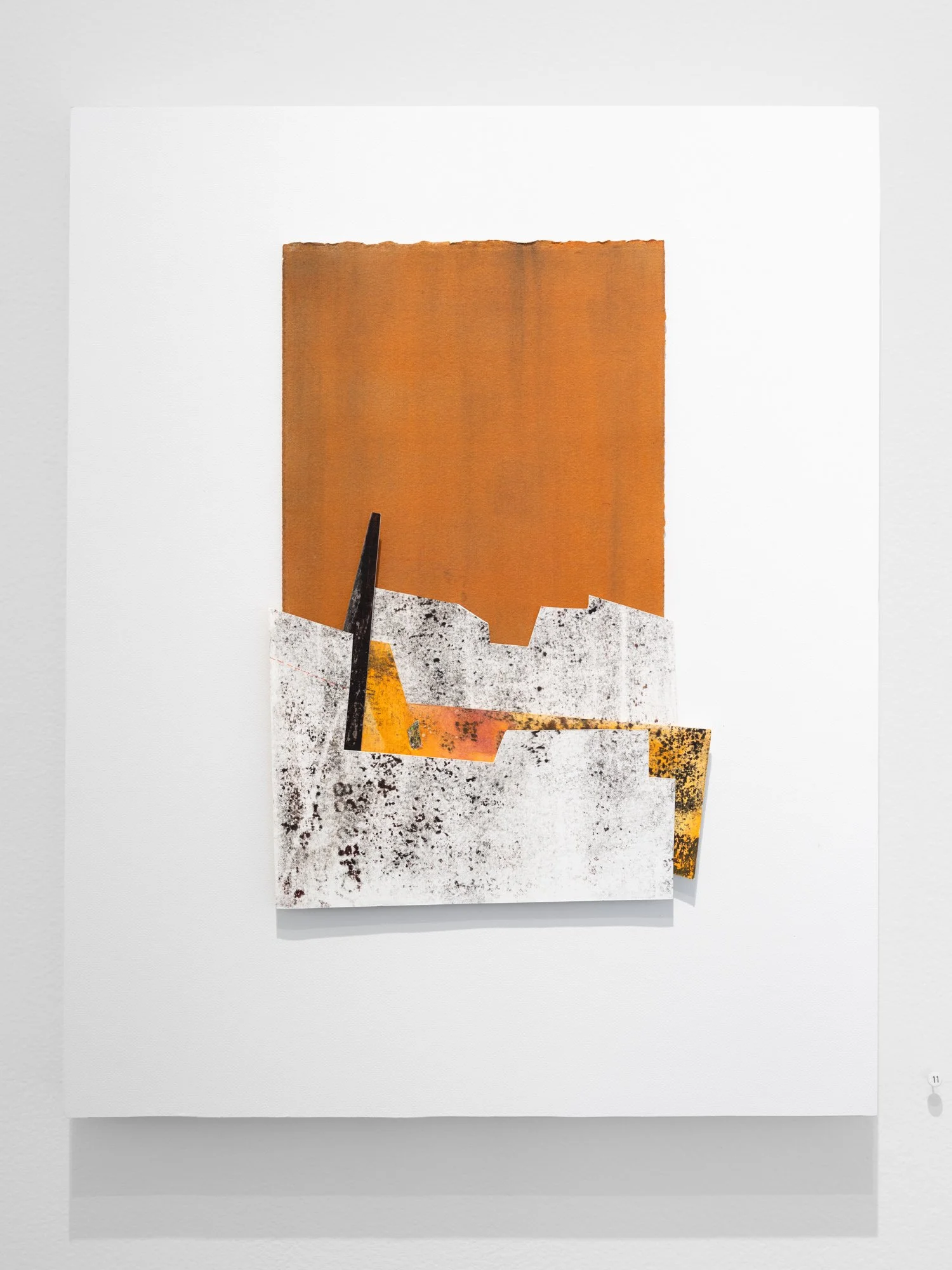 A collage of textured, layered paper with various abstract colors and patterns, mounted on a white background.