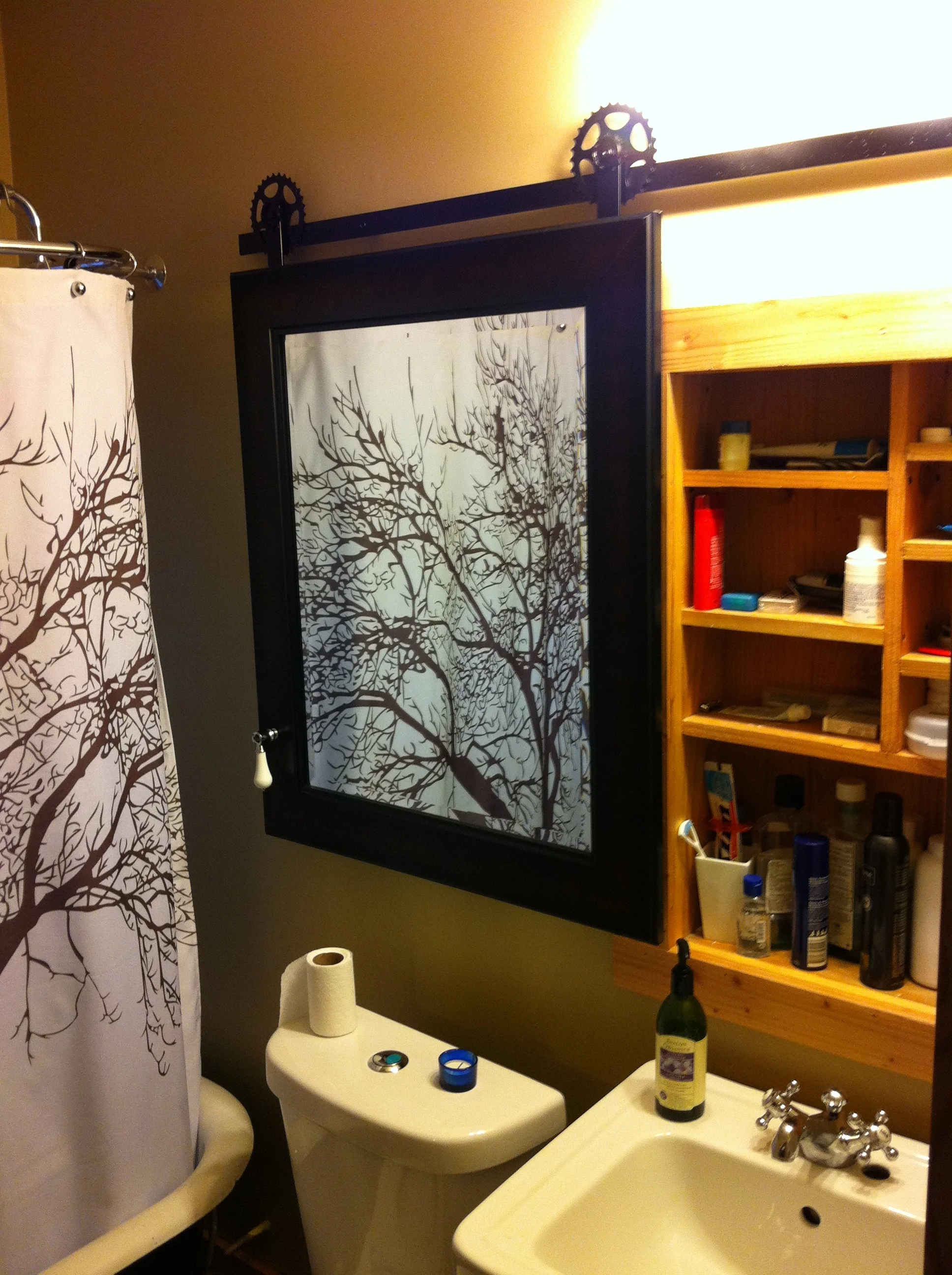 Sliding medicine cabinet mirror utilizing reclaimed bike parts.