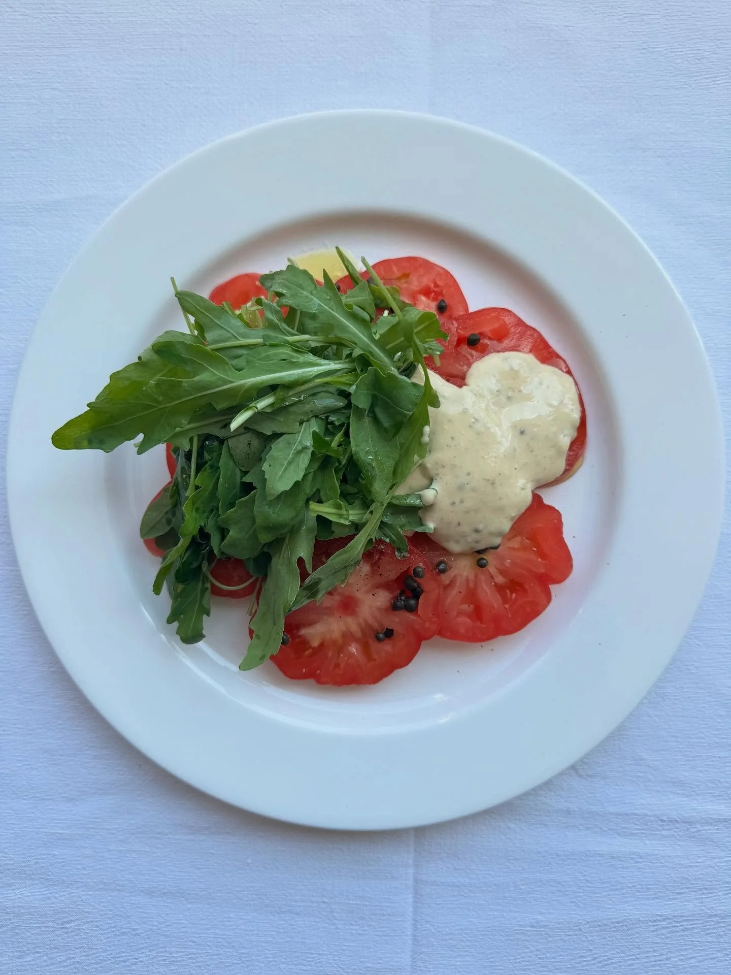 Tomato tonnato, rocket and capers. A take on the Piedmontese classic with cold sliced veal. Beautiful Cuore di bue rosa tomatoes, creamy tuna and anchovy mayonnaise with a lemony handful of rocket. Perfect hot weather food served at a Taylor and Lake