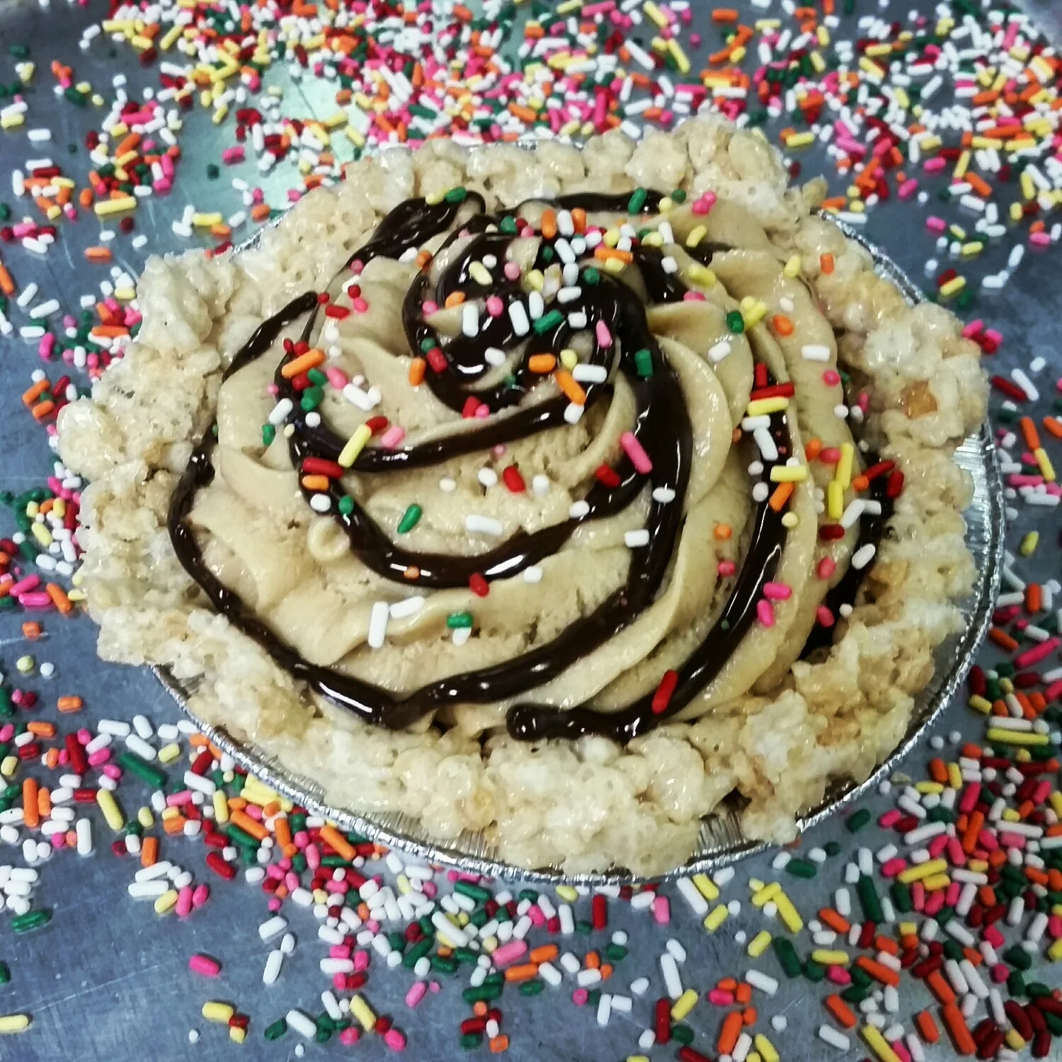 Childhood Memories- A peanut butter mousse in a rice crispy crust, finished with our bittersweet chocolate ganache & sprinkles. 