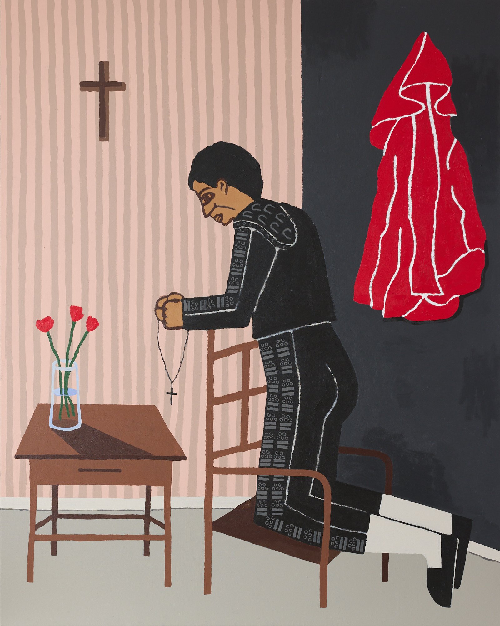 A MATADOR KNEELING IN PRAYER BOFORE A BULLFIGHT IN A ROOM WITH PINK STRIPED WALLS WHERE A CROSS HANGS AND A FLOWER VASE WITH ROSES ON THE SIDE TABLE