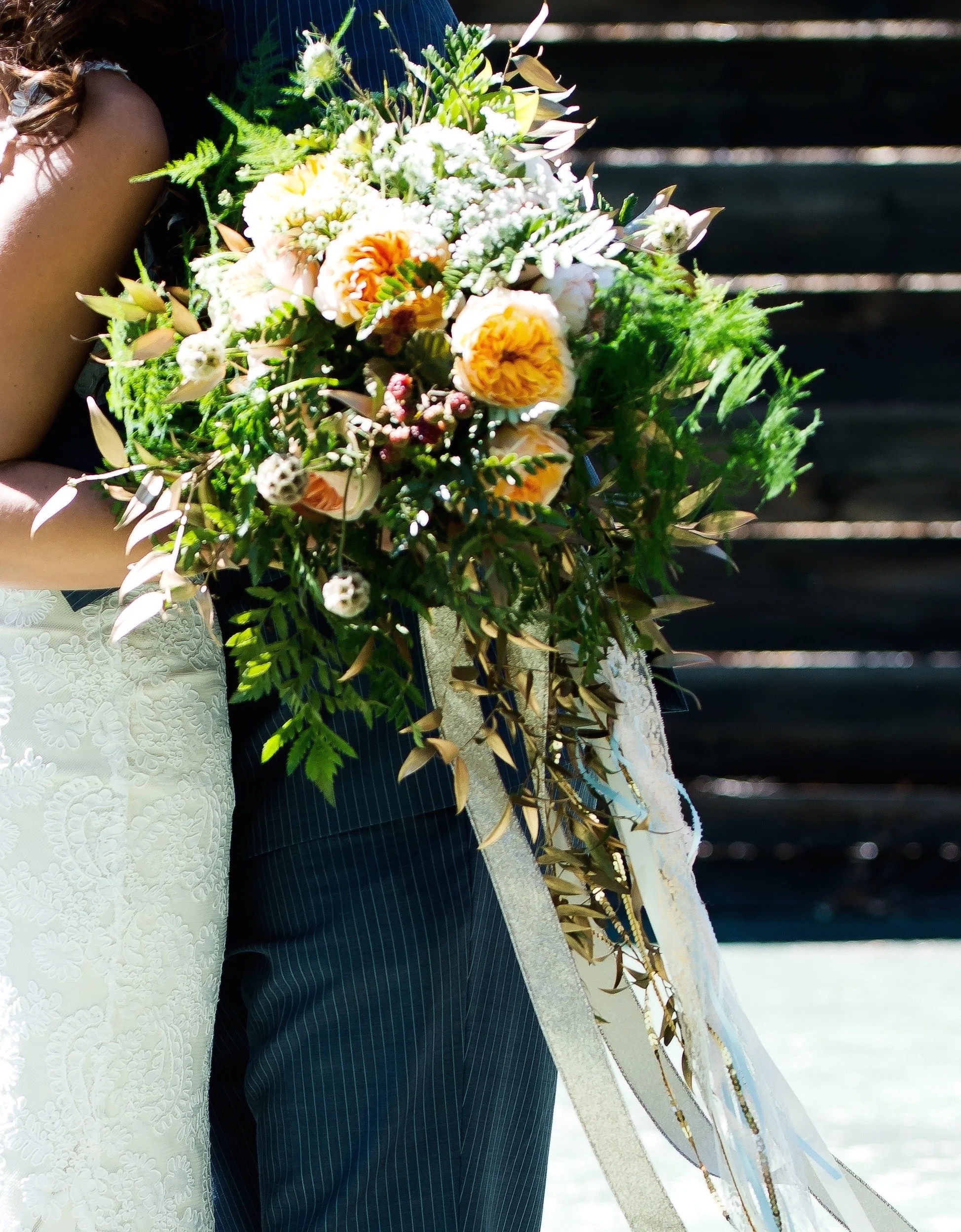 Romantic peach bridal bouquet with gold streamers