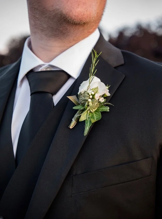 Groom's white boutonniere, rose, scabiosa buds, ivy