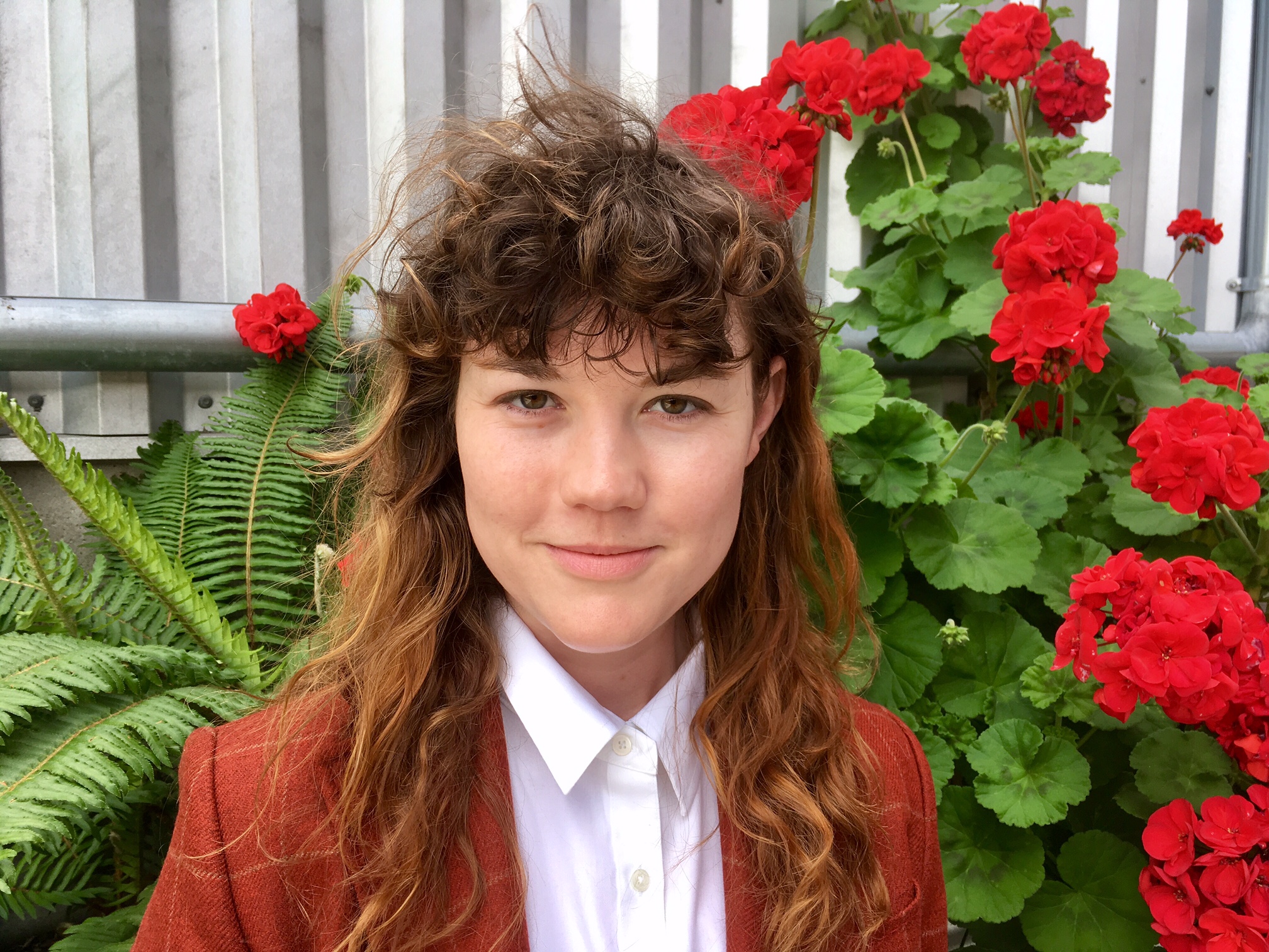 Sonja San Francisco Couples Counselor and Sex Therapist standing in front of red flowers after successful marital counseling session