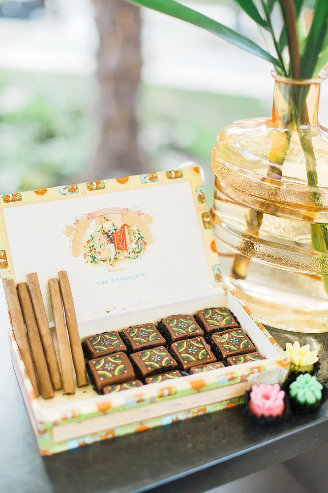 A big part of the Cuban look was in the vintage details - old cigar boxes, vintage wooden trays and rustic candleholders. We put together a Cocktails, Chocolates and Cigar bar for a late-night reception treat. We used little tropical bird details on the coral napkins, and on the dining table we put together vintage-looking goblets and vases with muted teal plates and wooden cutlery. We didn’t want it to look polished, but rather like a curated collection, as if we had just found a lot of what we used. Like an impromptu Cuban wedding!