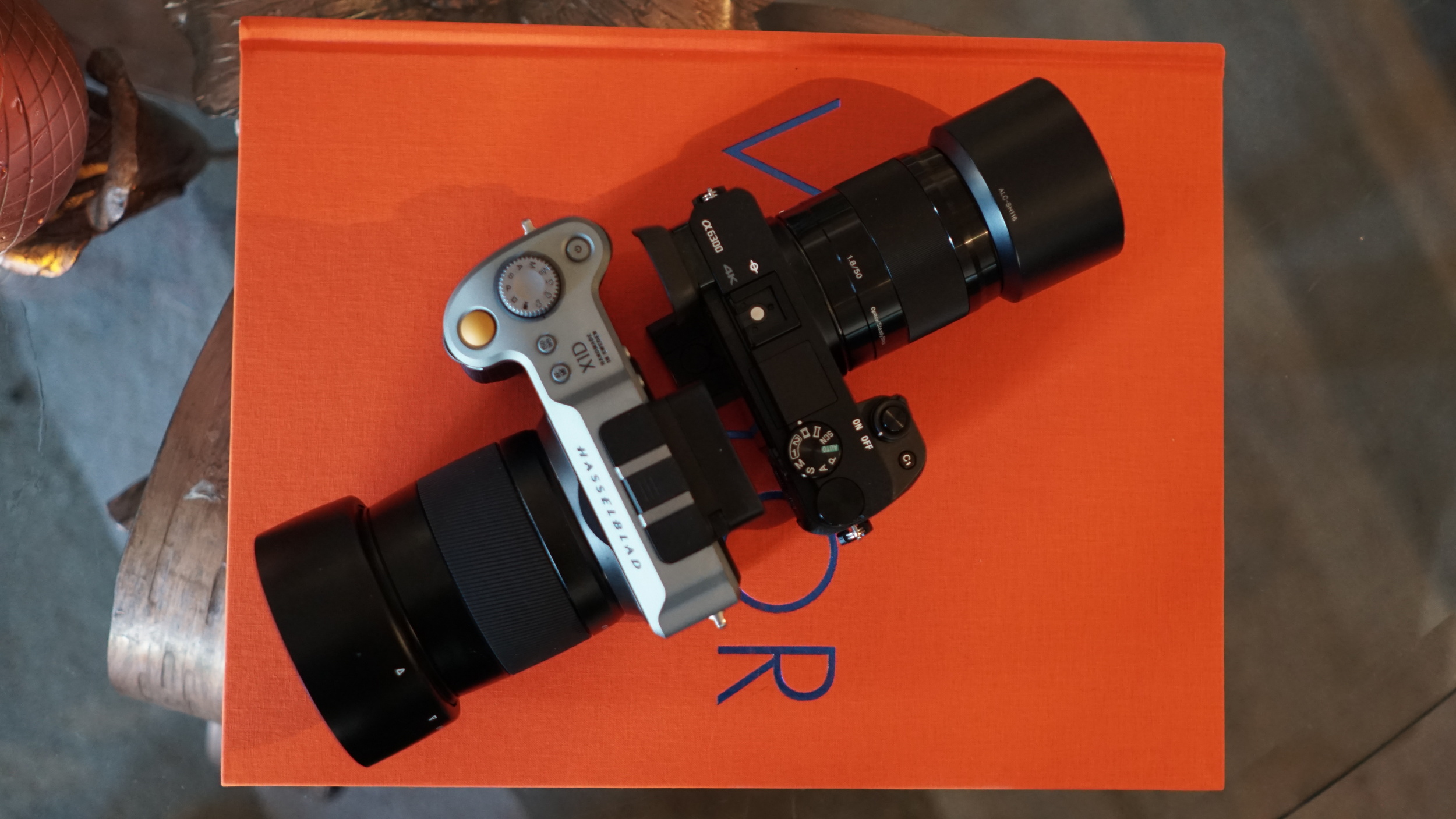 The a6300 is just 100g lighter. That's Sony's E 50mm f/1.8 OSS lens on it, yielding about the same field of view as that 90 on the X1D. 