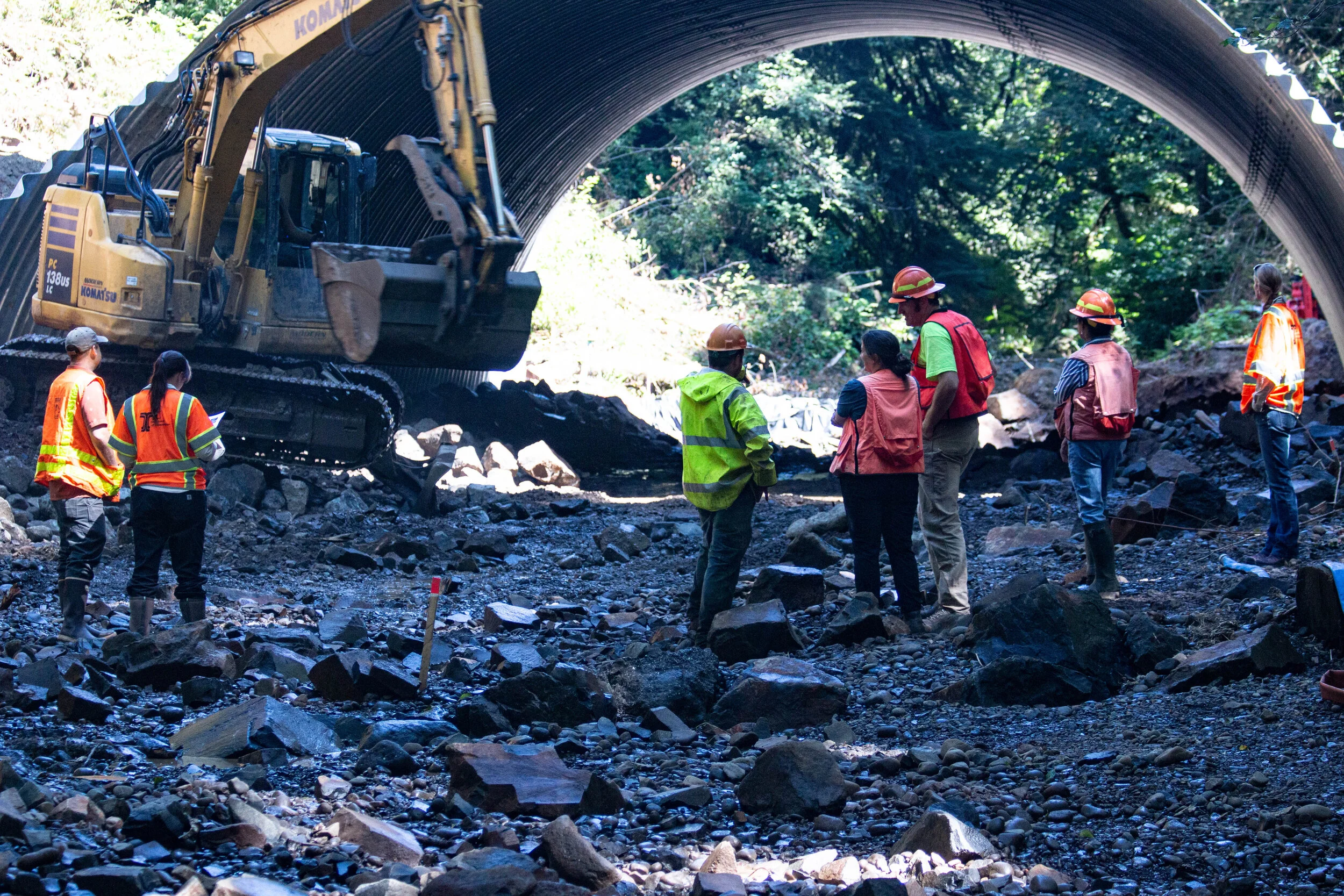 ODOT, MCWC, and USFS personnel view the placement of stream simulation under the new culvert to ensure they meet the engineered designs, meant to mimic a natural streambed.