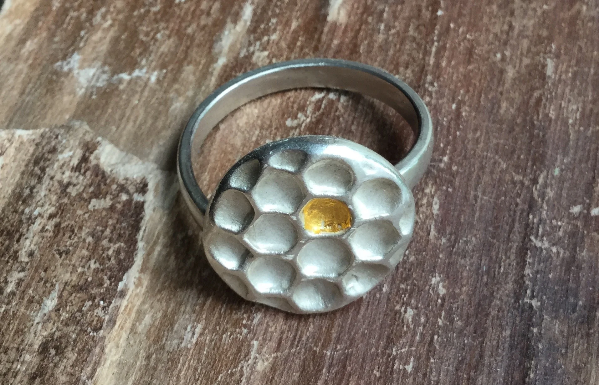 The ring. I made this with fine silver for the honeycomb center piece (Art Clay Silver), 24kt gold foil for the 'honey' and Sterling silver for the ring band. It's adjustable, too.