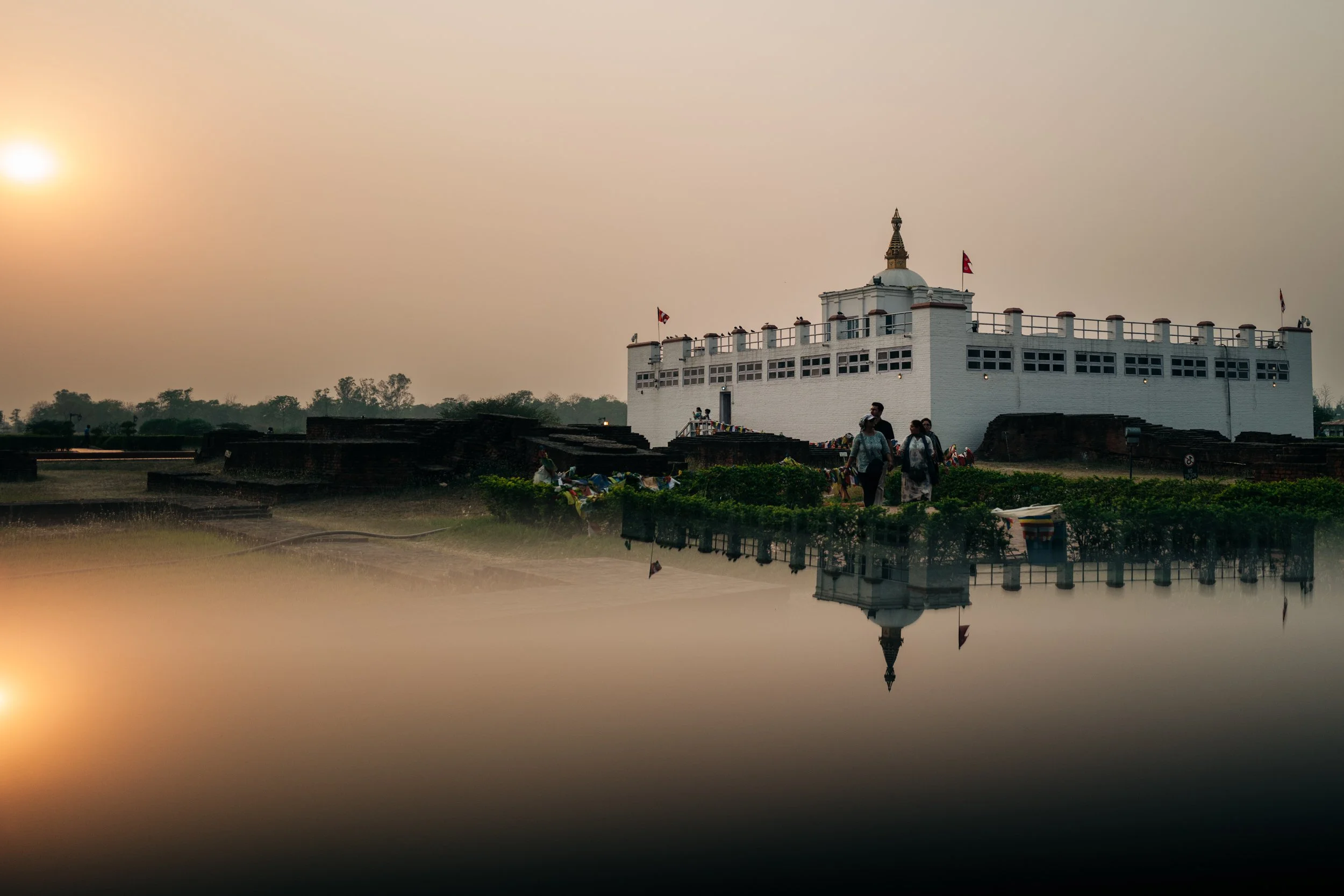 Maya Devi Temple, Lumbini bathed in warm late-afternoon light with its prism-created reflection.