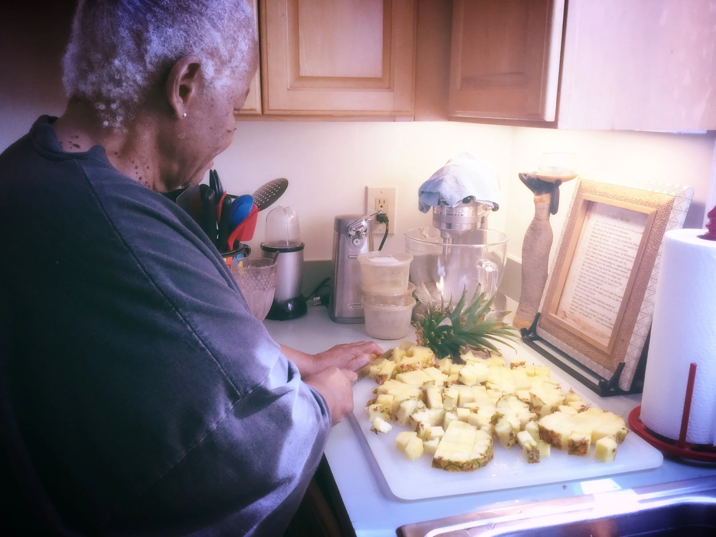 Grannie chops up fresh pineapples, nothing wasted, including the core and thorny outer skin goes into her smoothie
