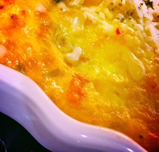 Half the cheese mixed in with eggs, half sprinkled atop