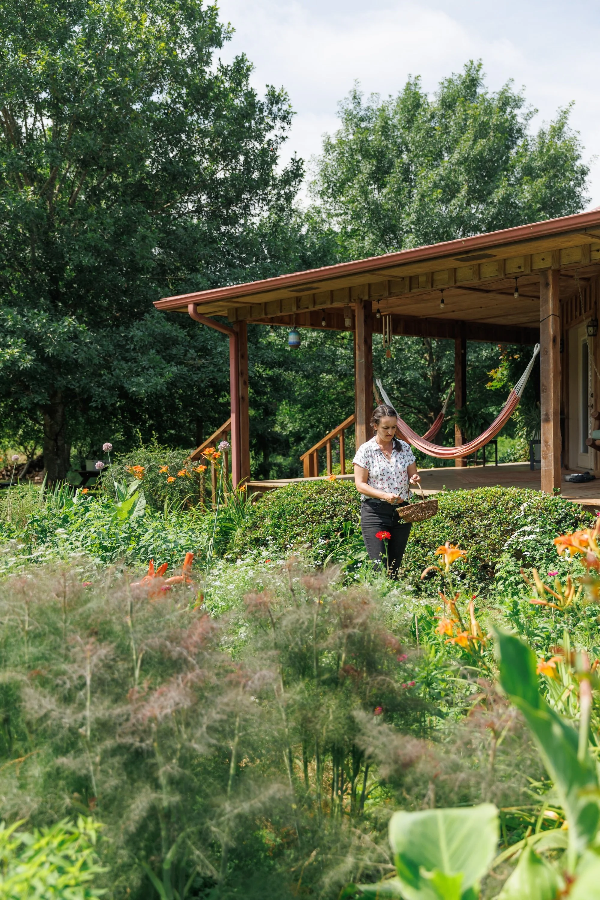 Melissa in the flower and vegetable beds below the porch at Wildland Gardens