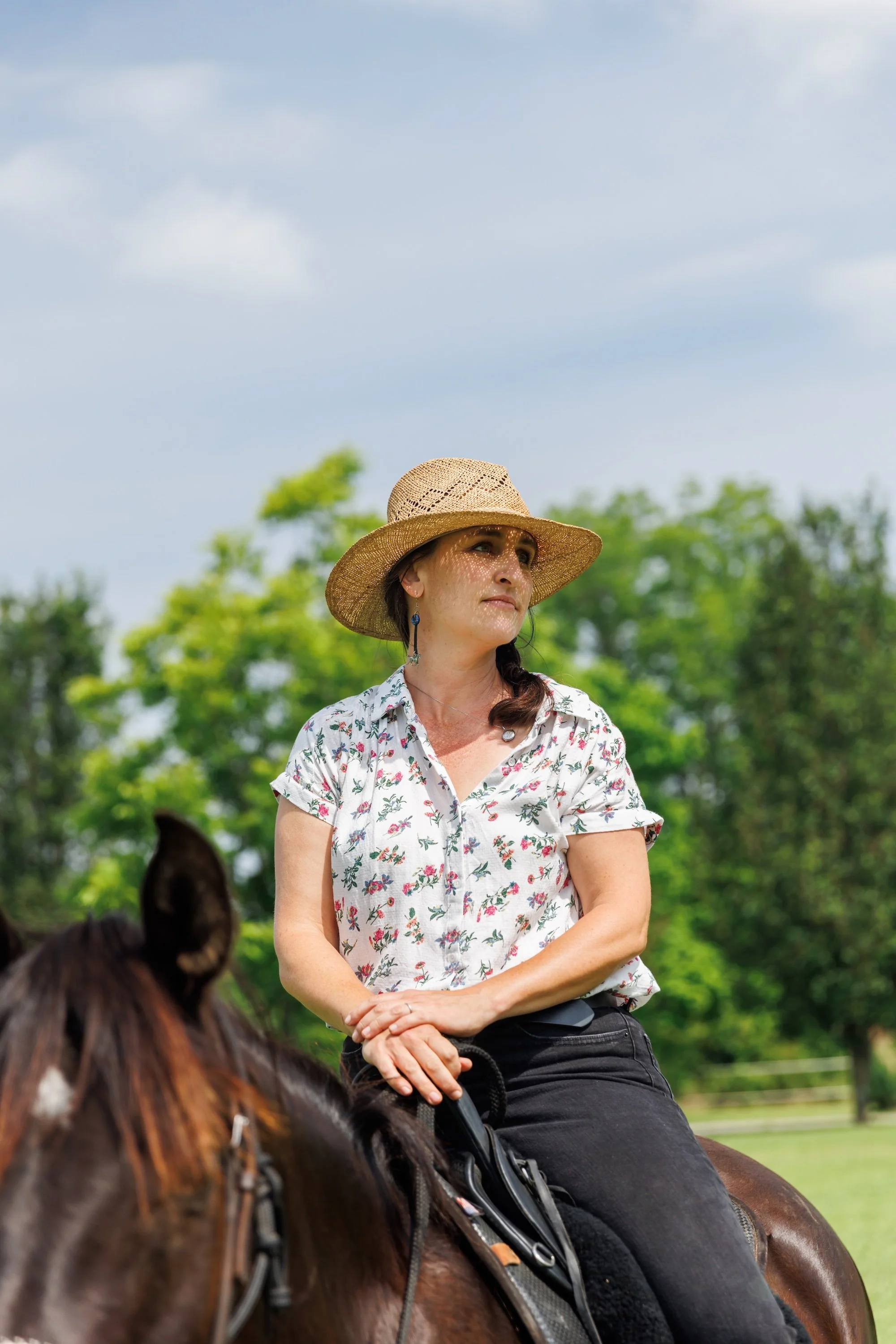 Melissa Cowper-Smith on her bay horse in a green pasture