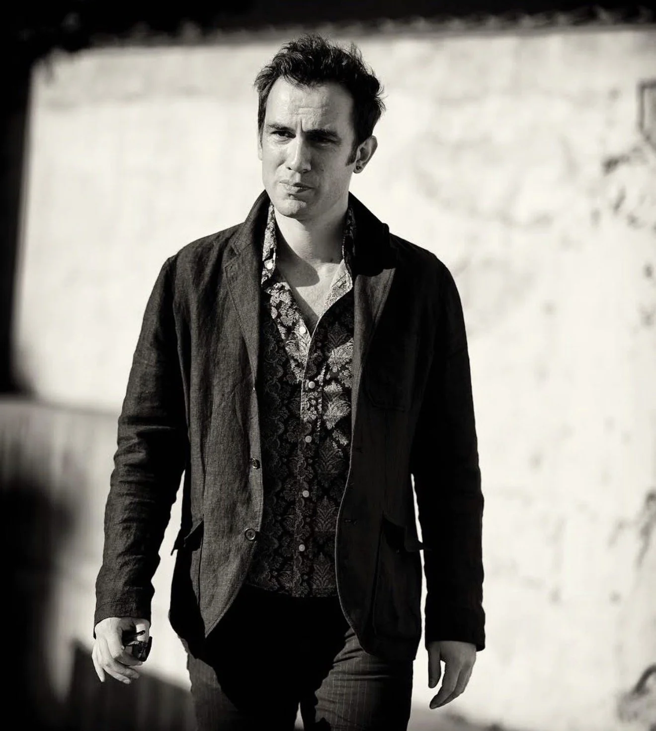 ack Rubinacci, singer-songwriter, black and white portrait whilst filming walking