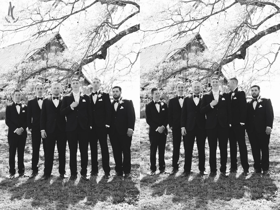 Groomsmen pose and laugh in a black and white picture.