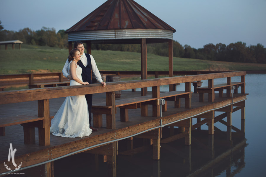 Bride and Groom snuggling on dock at sunset