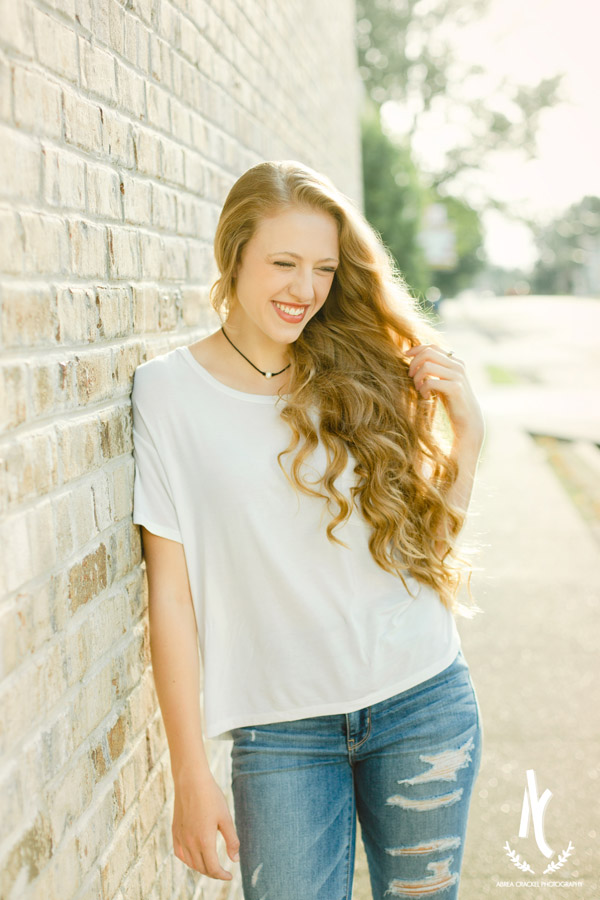 High School Senior laughing against a brick wall in Downtown Martin, Tennessee