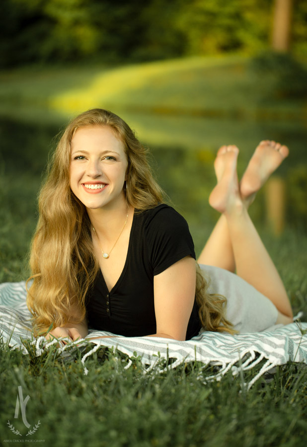 High School Senior lying on grass beside a pond in Martin, Tennessee 