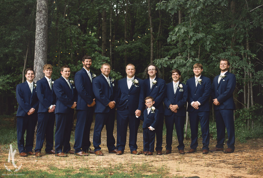 Groomsmen in navy suits with ring bearer