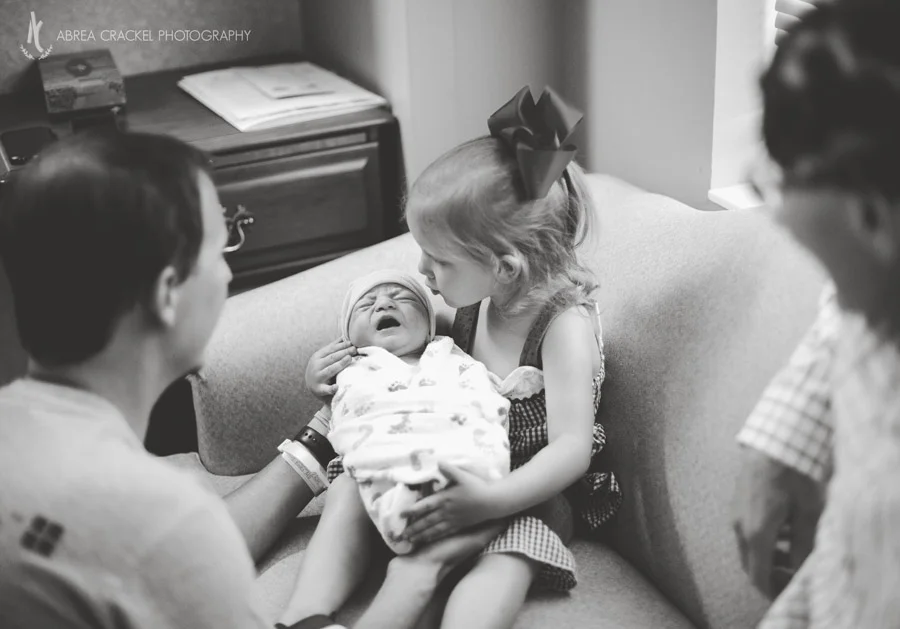 Holding her baby sister like a pro already