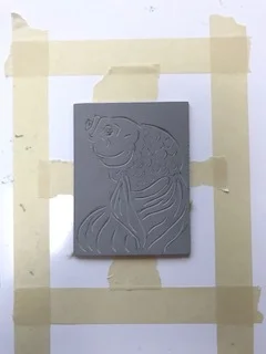 Here, I have carved the design into the linoleum, and have centered it inside the frame of the paper size I'll be using.