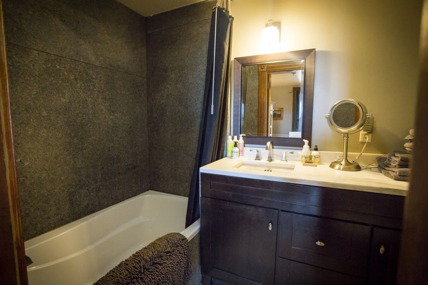 The master bathroom has an oversize tub, marble counter and floor